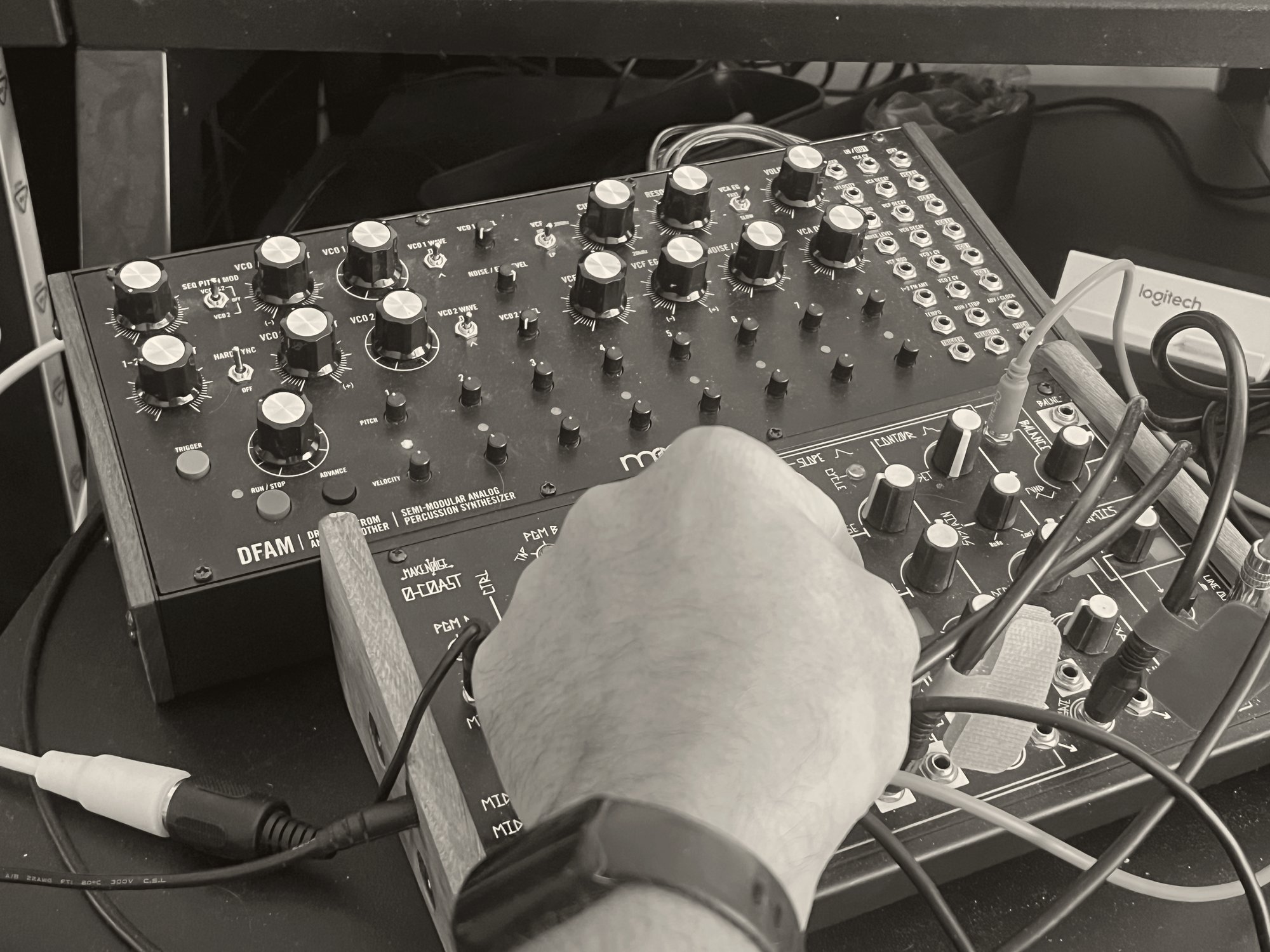 A hand at work patching the Moog&nbsp;DFAM and Make&nbsp;Noise&nbsp;O-Coast — the kind of guidance the studio offers with complex instruments.